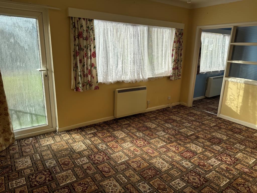 Lot: 62 - GROUND FLOOR FLAT WITH GARAGE FOR INVESTMENT OR OCCUPATION - Living room with pattern carpet and painted walls
